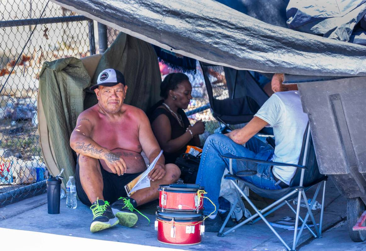 Homeless people escape the heat under a tarp shelter along North A Street in Las Vegas, Wednesd ...