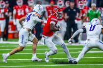 UNLV quarterback Hajj-Malik Williams (6) cuts past Boise State Broncos safety Ty Benefield (0) ...