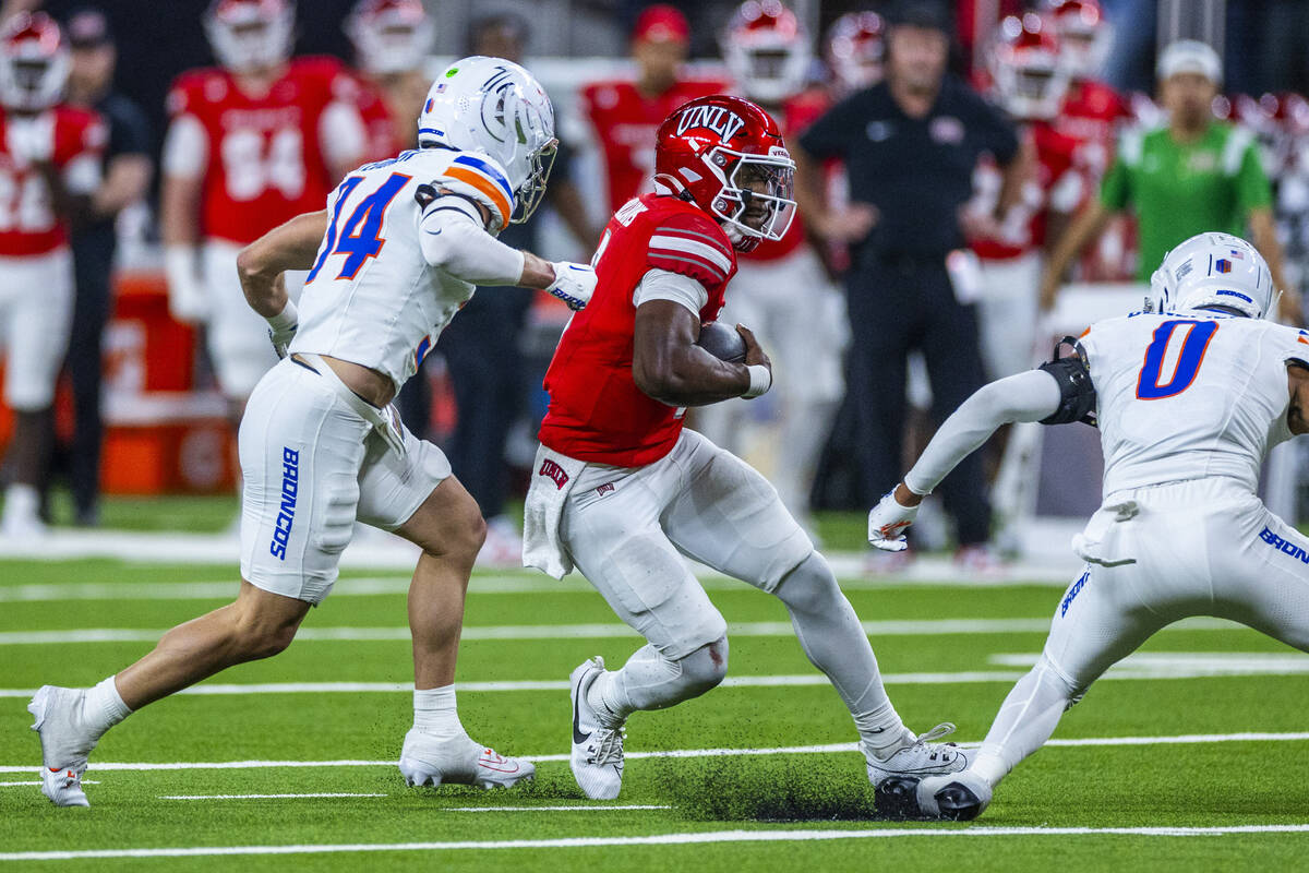 UNLV quarterback Hajj-Malik Williams (6) cuts past Boise State Broncos safety Ty Benefield (0) ...