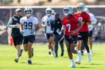 Raiders quarterback Geno Smith (7) and tight end Brock Bowers (89) move to another spot with te ...