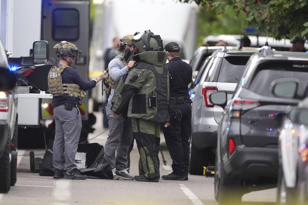 Law enforcement officials dress up in protective gear to investigative an attack on the Pearl S ...