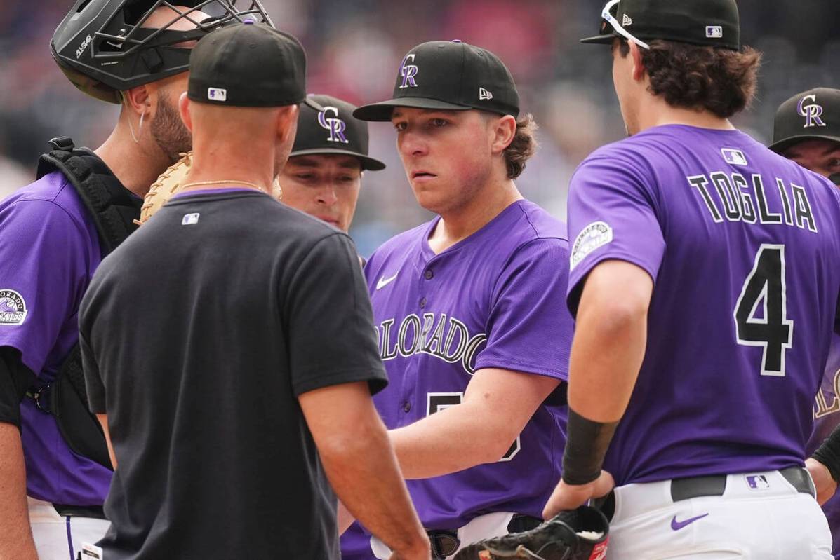 Colorado Rockies interim manager Warren Schaeffer, front left, takes the ball from relief pitch ...