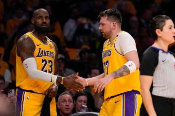Los Angeles Lakers guard Luka Doncic, right, celebrates with teammate forward LeBron James duri ...
