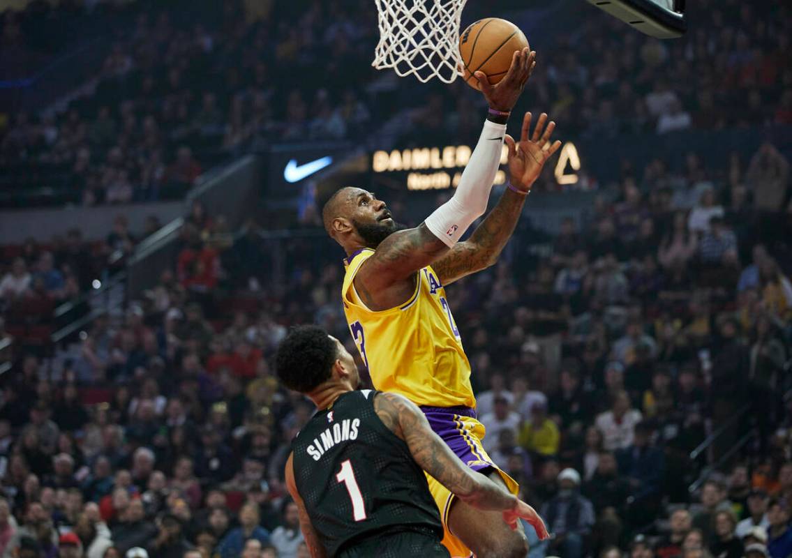 Los Angeles Lakers forward LeBron James, right, shoots over Portland Trail Blazers guard Anfern ...