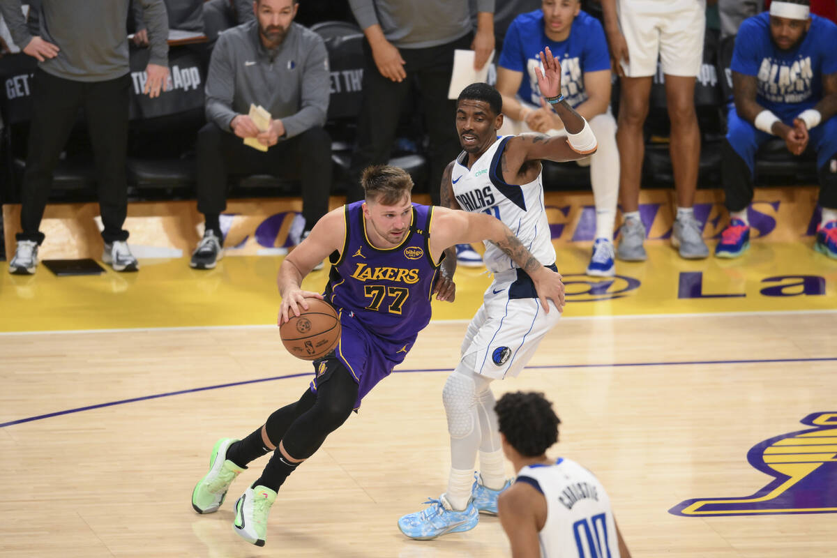 Los Angeles Lakers guard Luka Doncic (77) moves the ball while defended by Dallas Mavericks gua ...