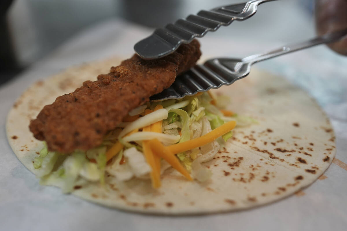 Charles L. Krumsiek, a McDonald's chef, puts a chicken on a tortilla to make a snack wrap at Mc ...