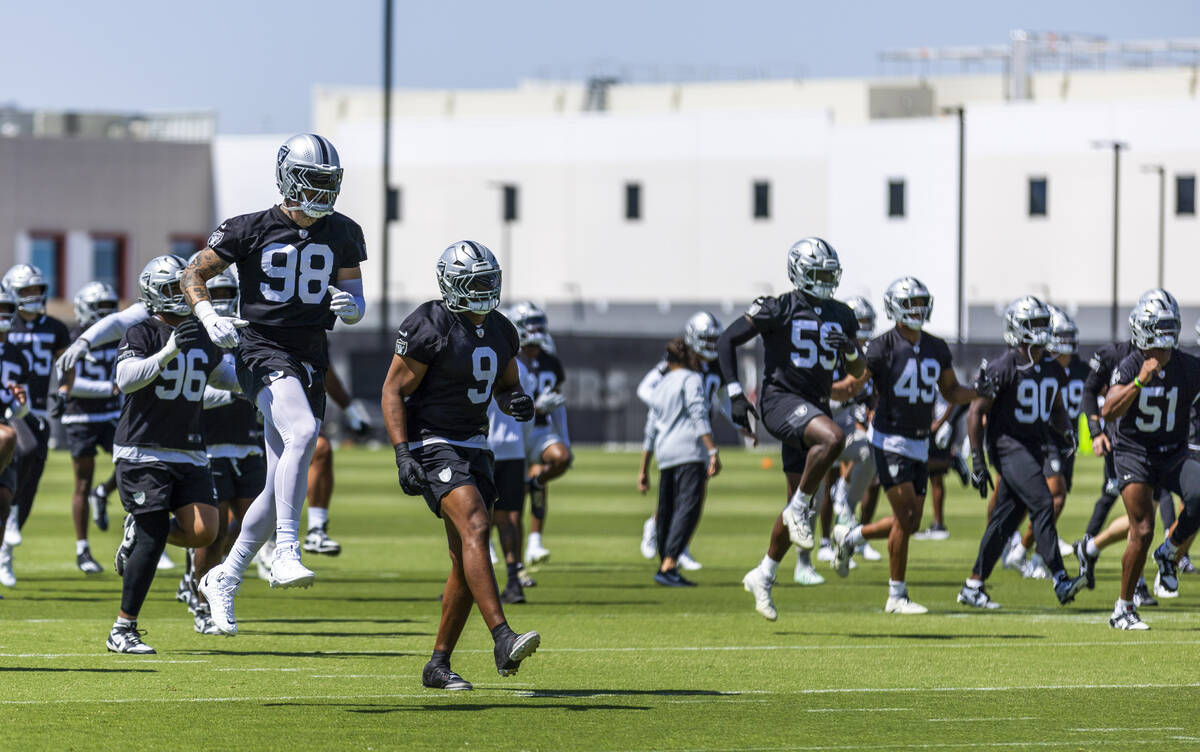 Raiders defensive end Maxx Crosby (98) and defensive end Tyree Wilson (9) join teammates while ...