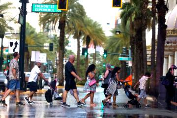 Pedestrians cross Casino Center Boulevard during a rainy afternoon on Tuesday, June 3, 2025, in ...