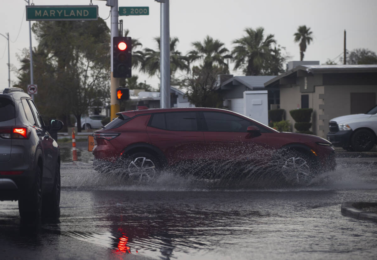Vehicles pass through floodwaters along Maryland Parkway on Tuesday, June 3, 2025, in Las Vegas ...