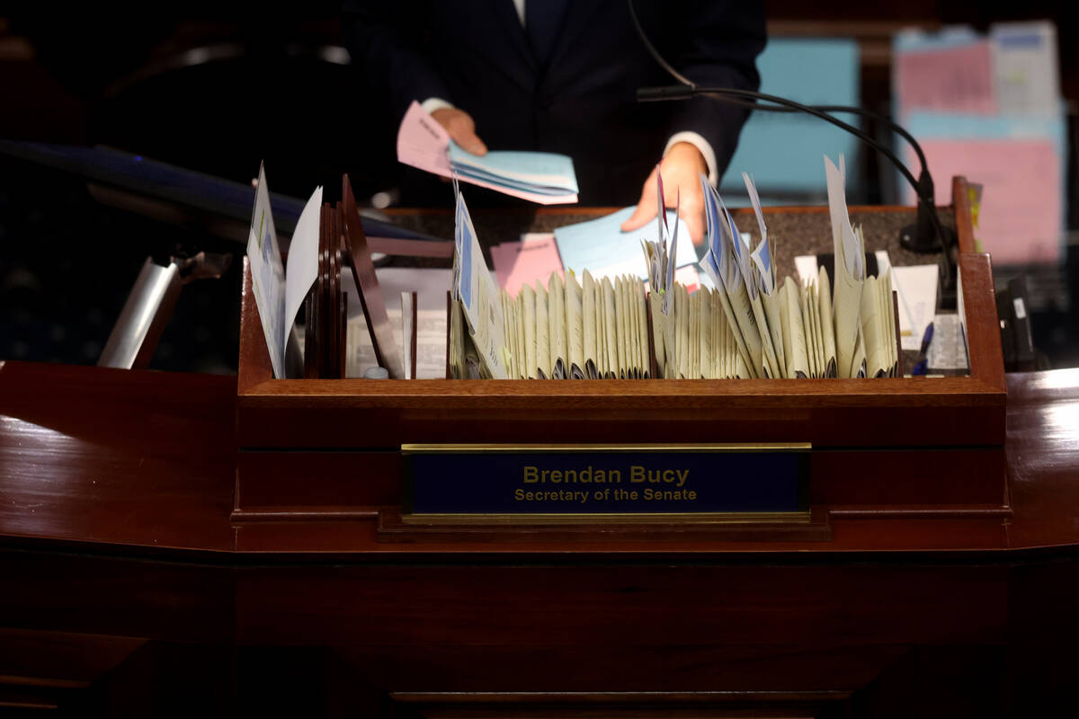 Secretary of the Senate Brendan Bucy organizes bills during a floor session on the final day of ...