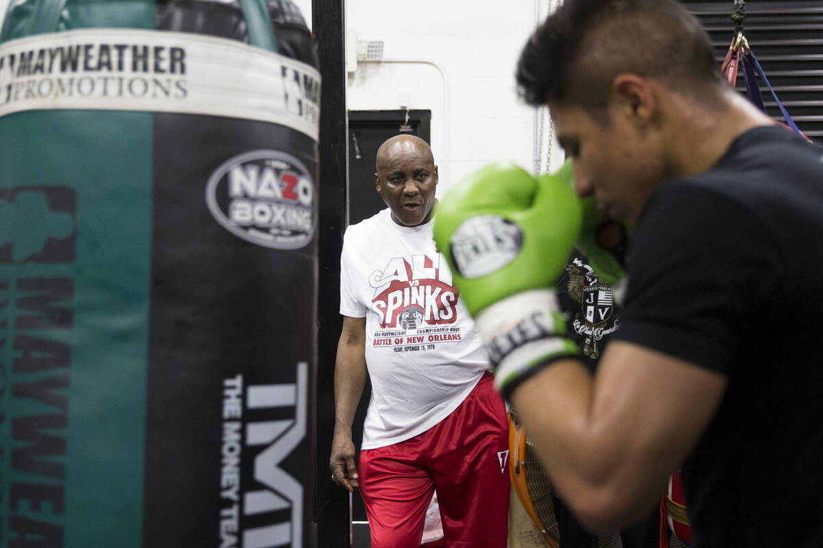 Boxing coach Mike McCallum, center, watches his fighter Jessie Vargas during a media workout ev ...