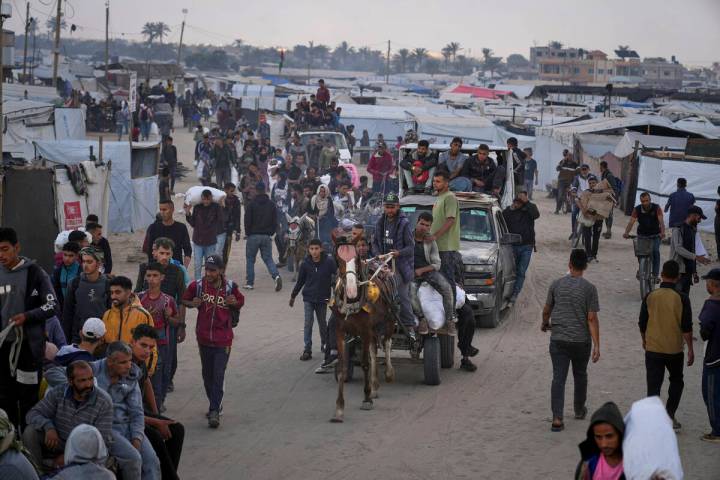 Palestinians carry bags filled with food and humanitarian aid provided by the Gaza Humanitarian ...