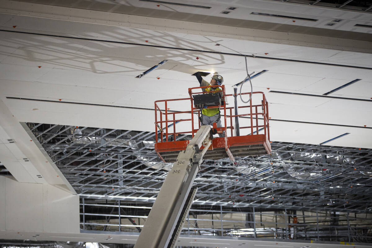 A construction worker makes adjustments from a lift as seen during a tour of the Las Vegas Conv ...