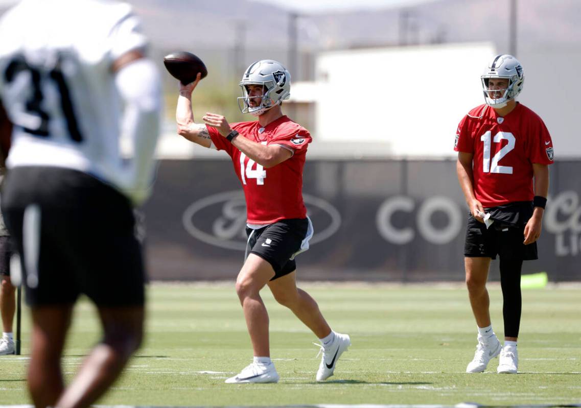 Raiders quarterback Aidan O'Connell (12) watches as quarterback Carter Bradley (14) throws the ...