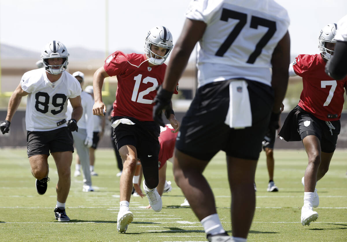 Raiders tight end Brock Bowers (89) quarterbacks Aidan O'Connell (12) Geno Smith (7) warm up du ...