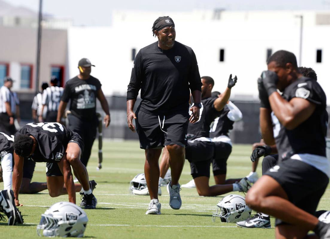 Raiders defensive coordinator Patrick Graham watches as players stretch during organized team a ...