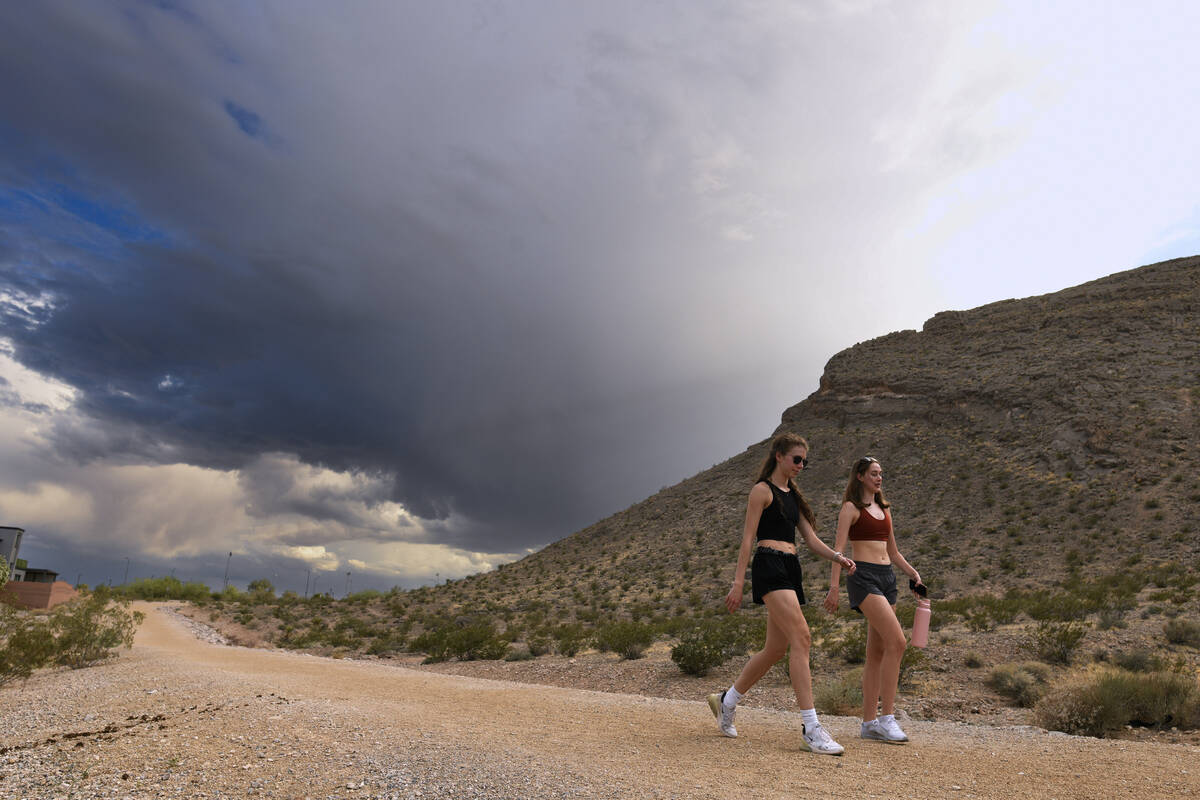 McKenna Pieper, left, and Rebecca Haftl take advantage of clearing skies to hike a trail at Lon ...