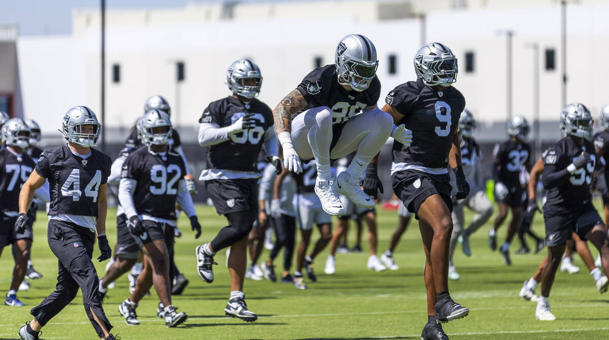 Raiders defensive end Maxx Crosby (98) and defensive end Tyree Wilson (9) join teammates while ...