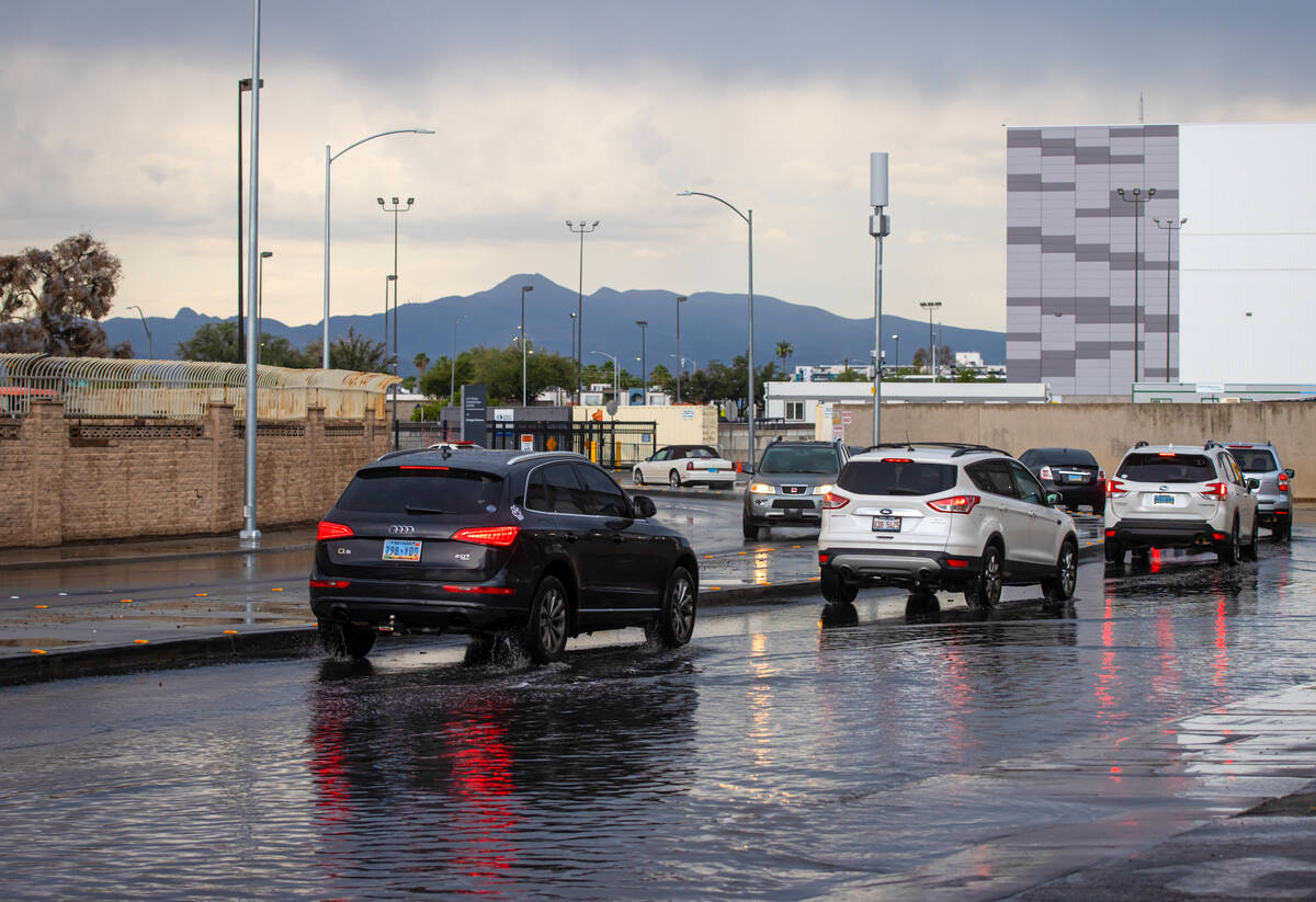Vehicles stay to the left to avoid flooding on Joe W. Brown Drive as rain comes down on Tuesday ...