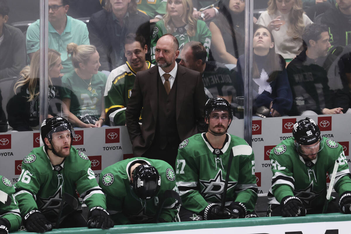Dallas Stars head coach Peter DeBoer stands behind players on the bench during the second perio ...
