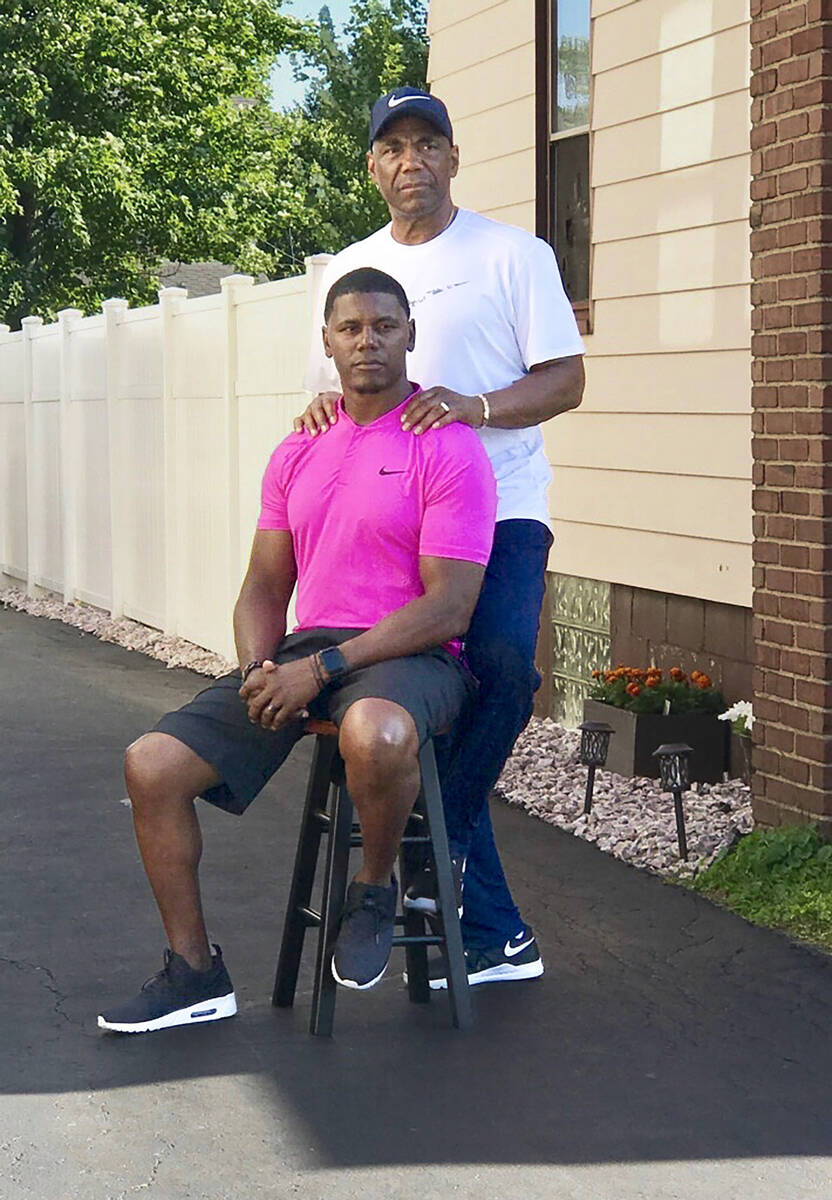 Deland McCullough, sitting, and his father, Sherman Smith, are shown in 2018. McCullough is now ...
