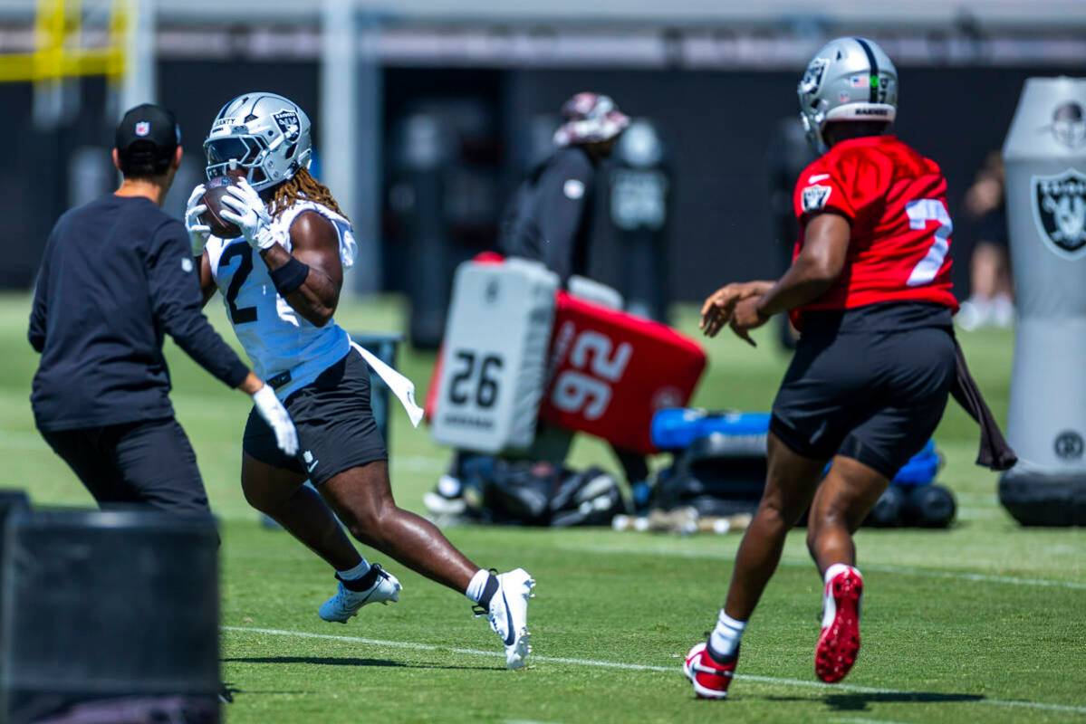 Raiders running back Ashton Jeanty (2) runs with the ball tossed by Raiders quarterback Geno Sm ...