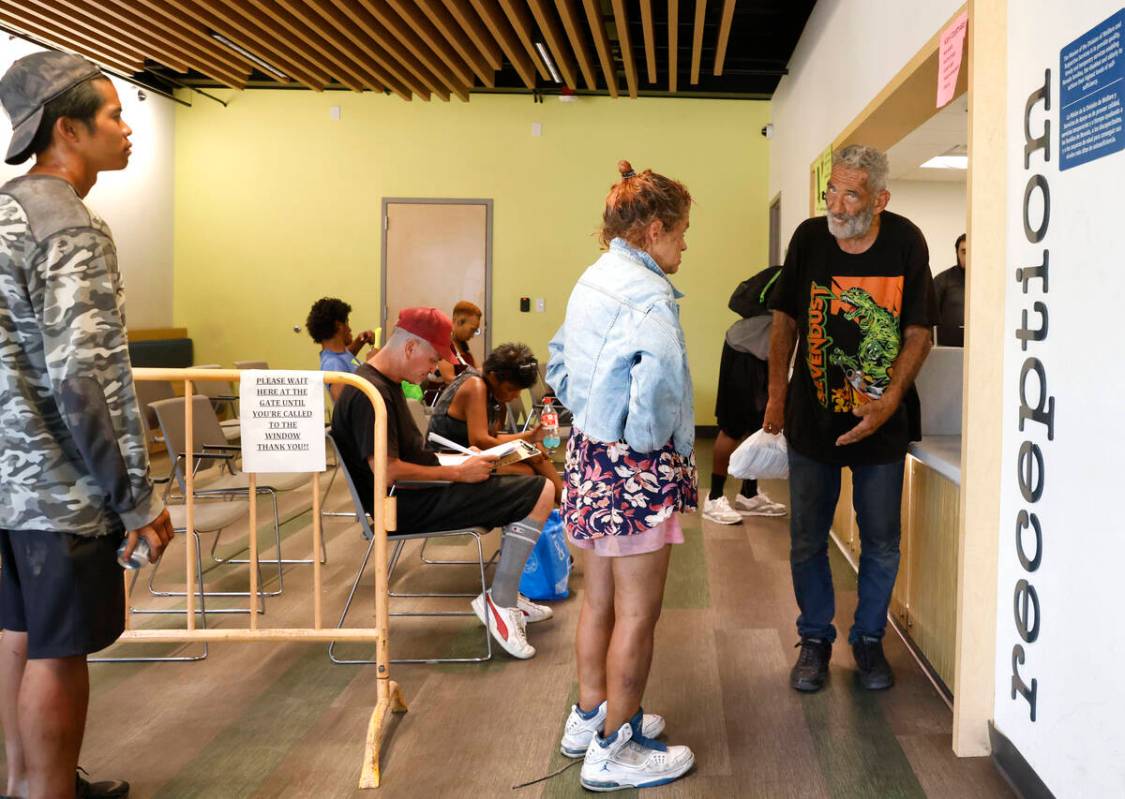 People line up to register and to stay indoor during a hot Monday afternoon at the Courtyard Ho ...