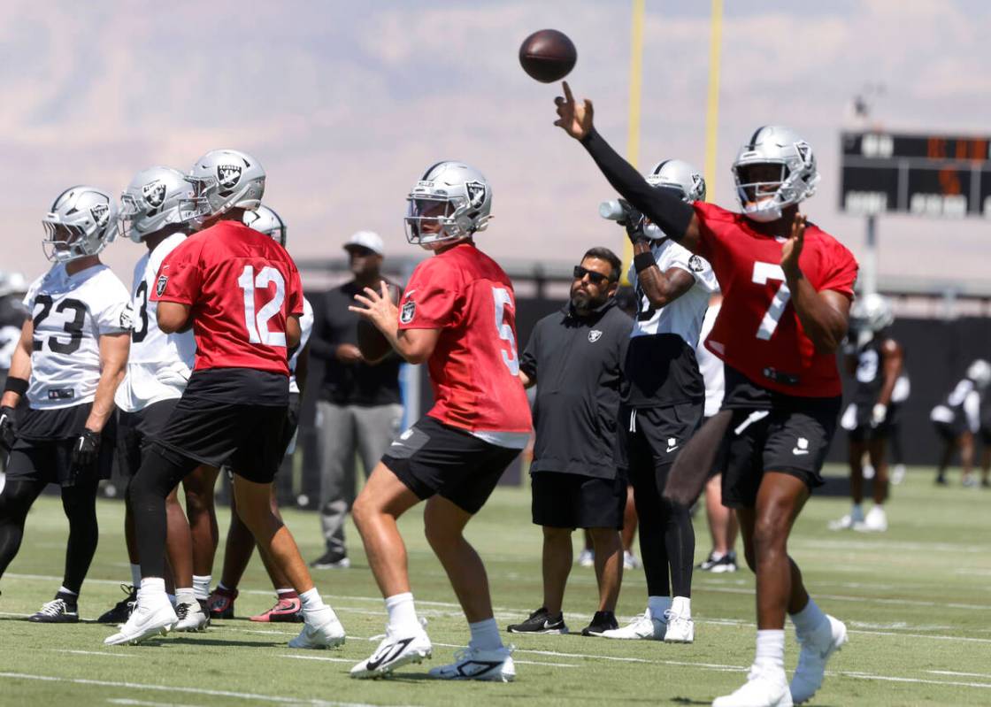 Raiders quarterback Geno Smith (7) throws the ball as quarterbacks Aiden O'Connell (12) and Ca ...