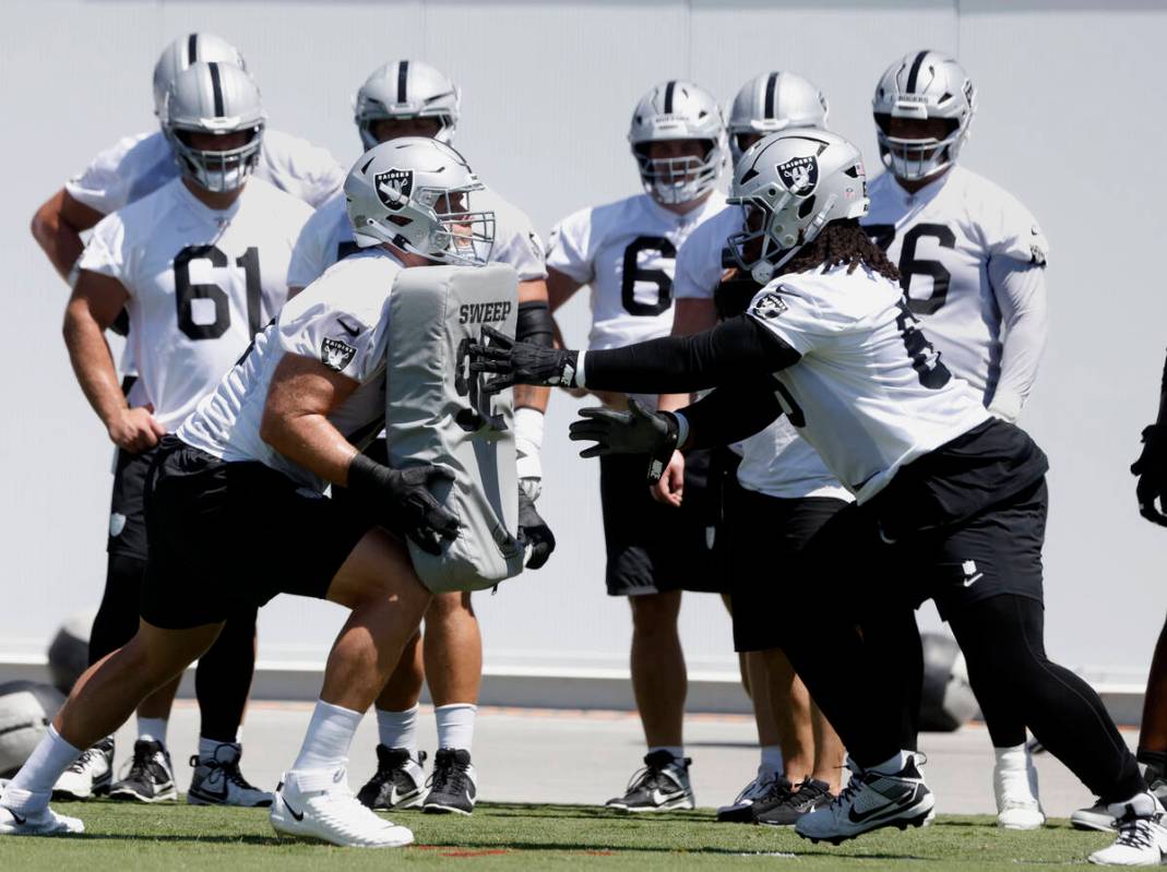Raiders offensive tackle Kolton Miller (74) and guard Dylan Parham (66) work on drills during a ...