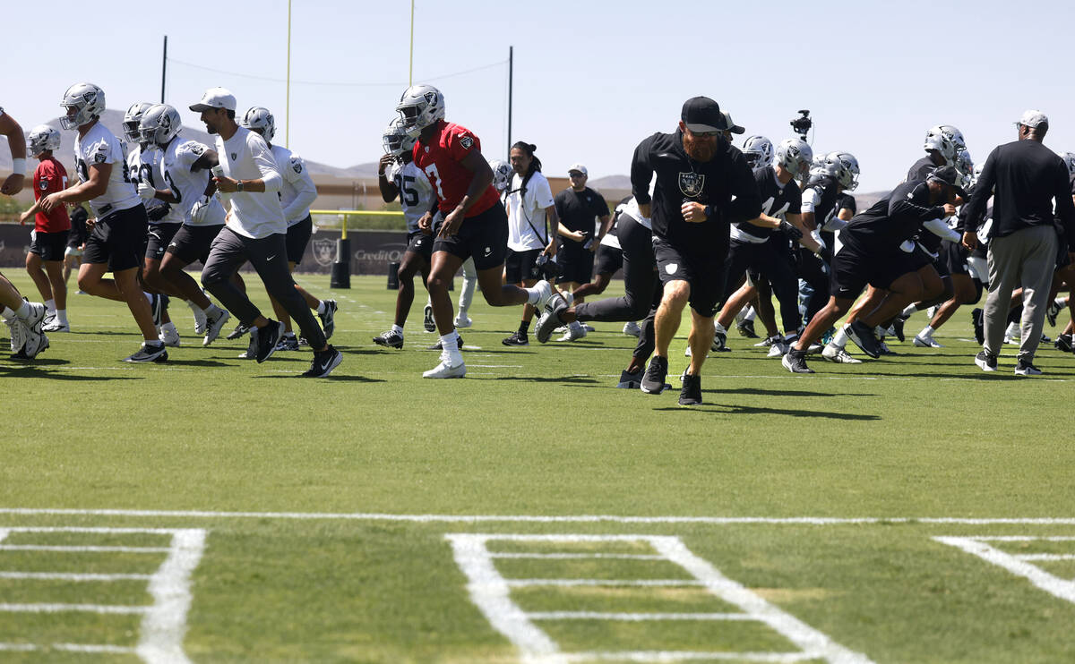 Raiders players, including quarterbacks Geno Smith (7) take the field during an NFL mandatory f ...