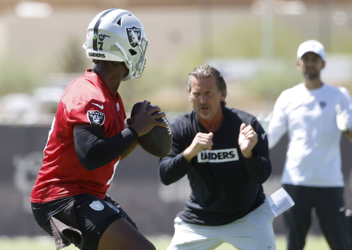 Raiders quarterback Geno Smith (7) works with quarterback coach Greg Olson during an NFL mandat ...