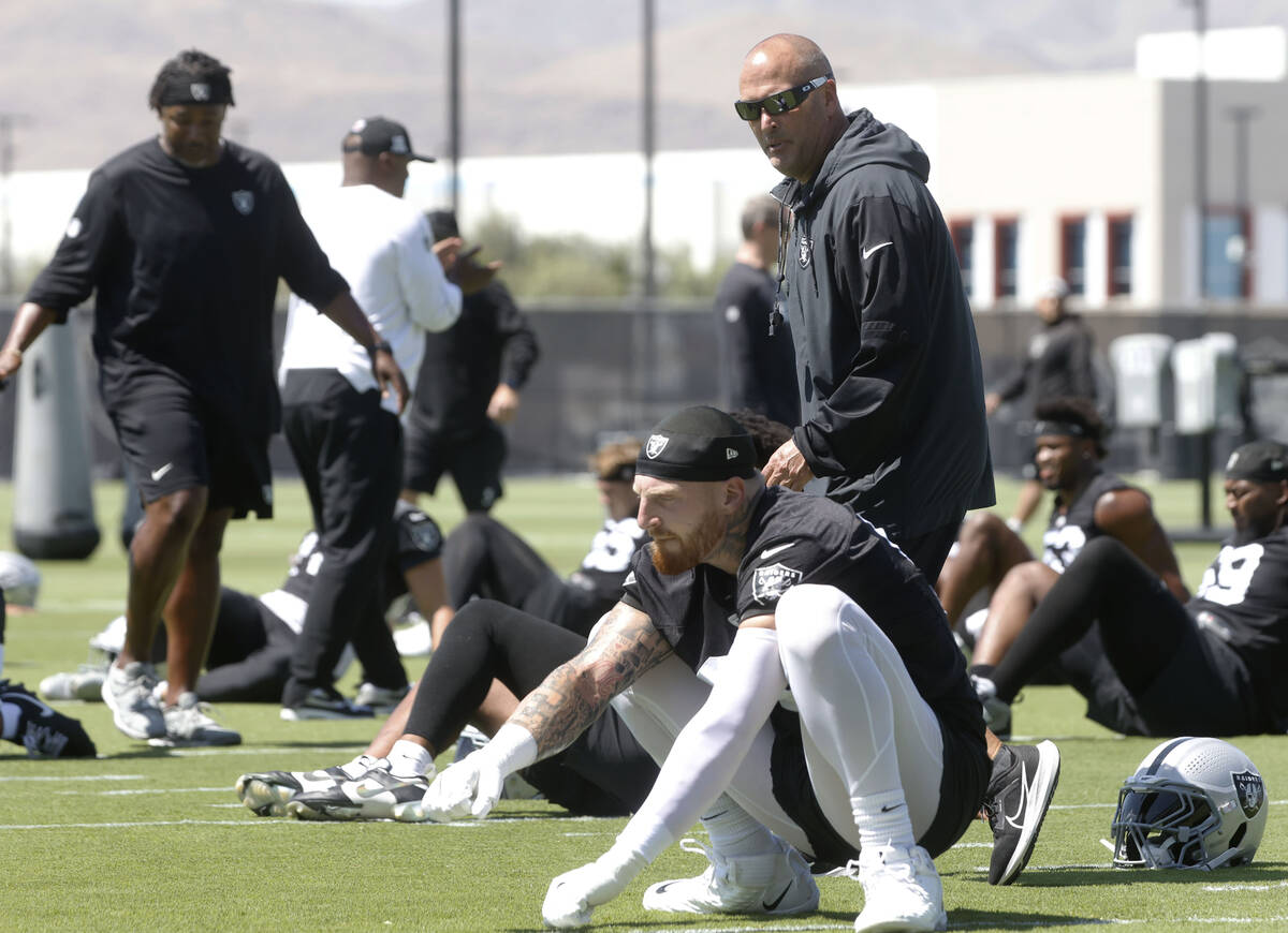 Raiders special teams coordinator Tom McMahon walls past defensive end Maxx Crosby (98) during ...
