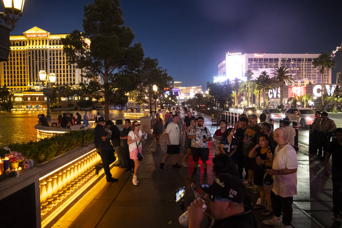 People gather by the Bellagio Fountains for a vigil in memory of Rodney Finley, a YouTube strea ...