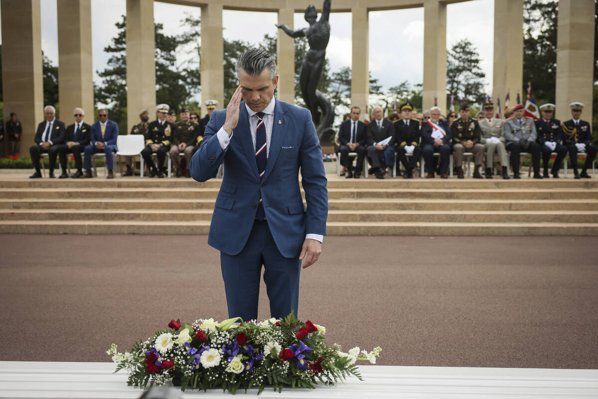 U.S. Defense Secretary Pete Hegseth lays a wreath of flowers during a ceremony at the US cemete ...