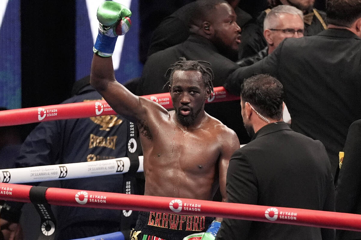 Terence Crawford, center, raises his fist as at the end of the 12 round fight against Israil Ma ...
