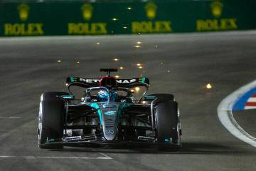 Mercedes driver George Russell sends some sparks flying while in the final turn on the track du ...