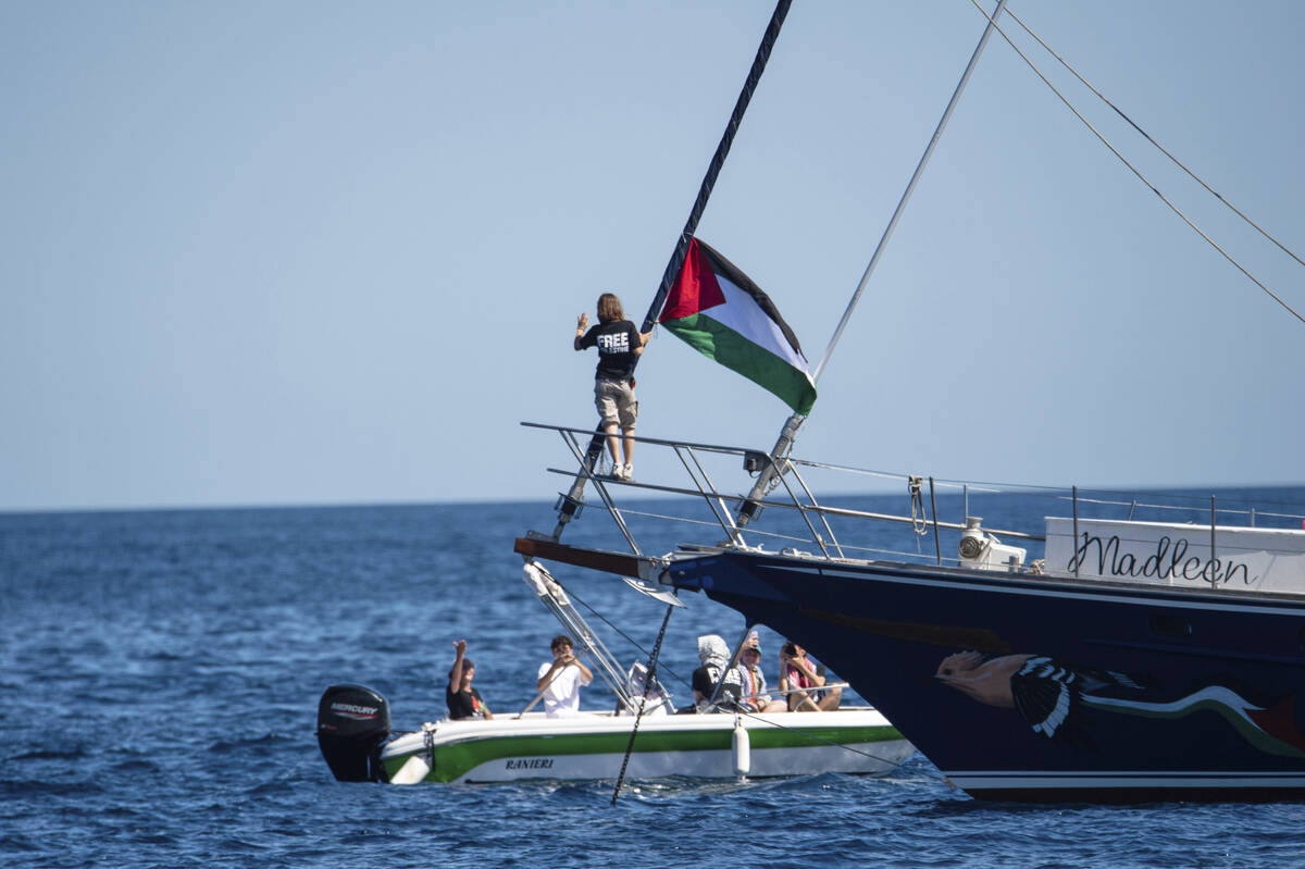 Climate activist Greta Thunberg stands near a Palestinian flag after boarding the Madleen boat ...