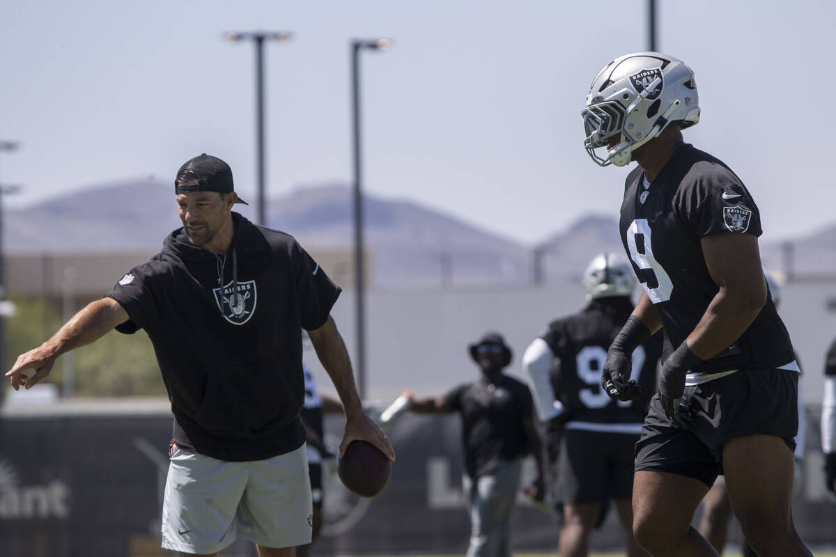 Defensive line coach Rob Leonard, left, instructs Raiders defensive end Tyree Wilson (9) in a d ...