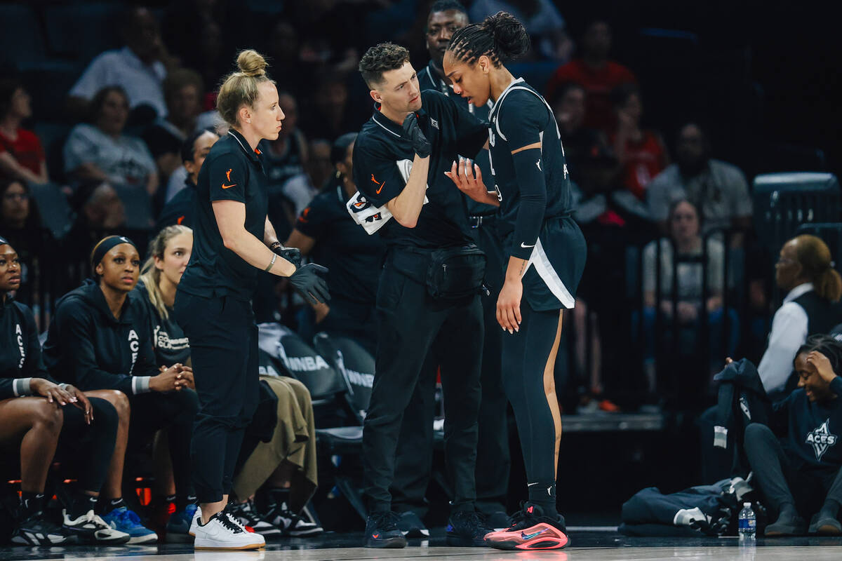 Aces center A'ja Wilson gets her nose checked out by medical staff during a WNBA basketball gam ...