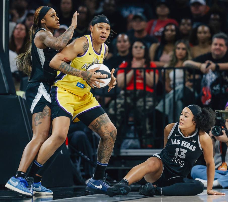 Aces guard Aaliyah Nye (13) takes a fall while defending Los Angeles Sparks forward Emma Cannon ...