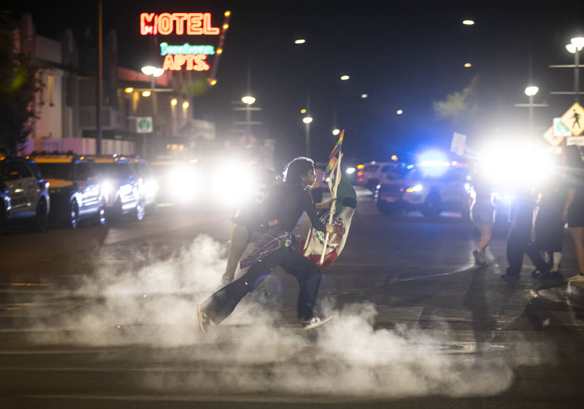 Protesters run as police deploy teargas on Fremont East on Wednesday, June 11, 2025, in downtow ...