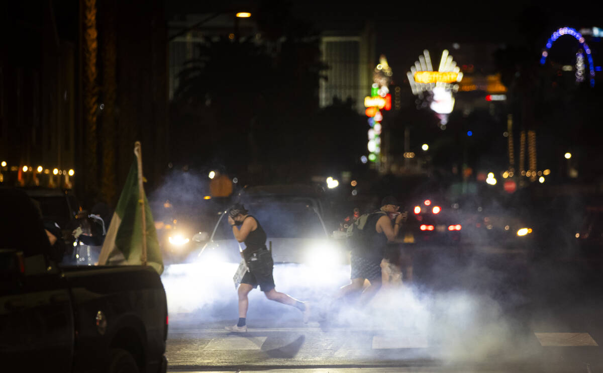 Protesters along Fremont Street run as Las Vegas police deploy tear gas on Wednesday, June 11, ...