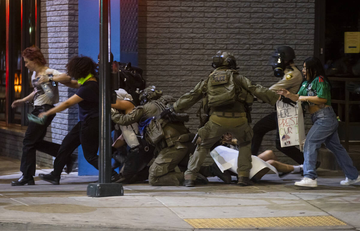 Las Vegas police officers chase down people protesting against ICE at Fremont Street and Maryla ...