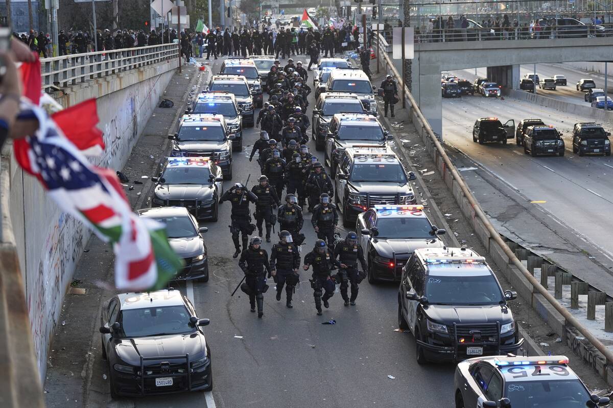 Officers make their way down a ramp to the 101 Freeway near the metropolitan detention center o ...