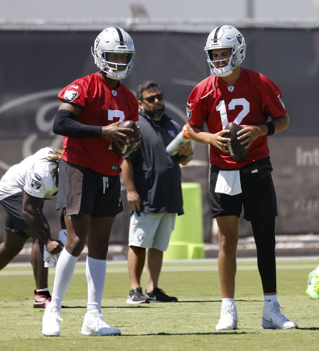 Raiders quarterbacks Geno Smith (7) and Aidan O'Connell (12) discuss during the last day of an ...