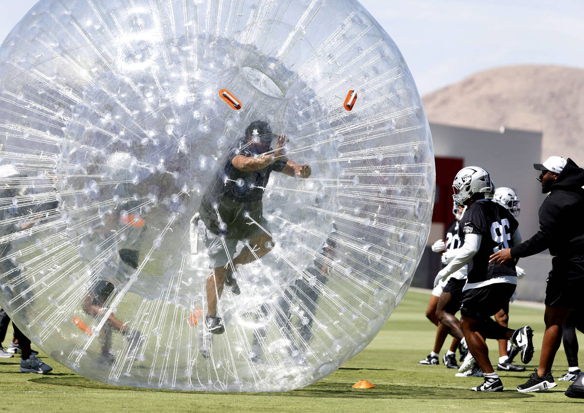 Raiders equipment manager John Miranda walks in an inflatable bubbl ball as players warm up dur ...