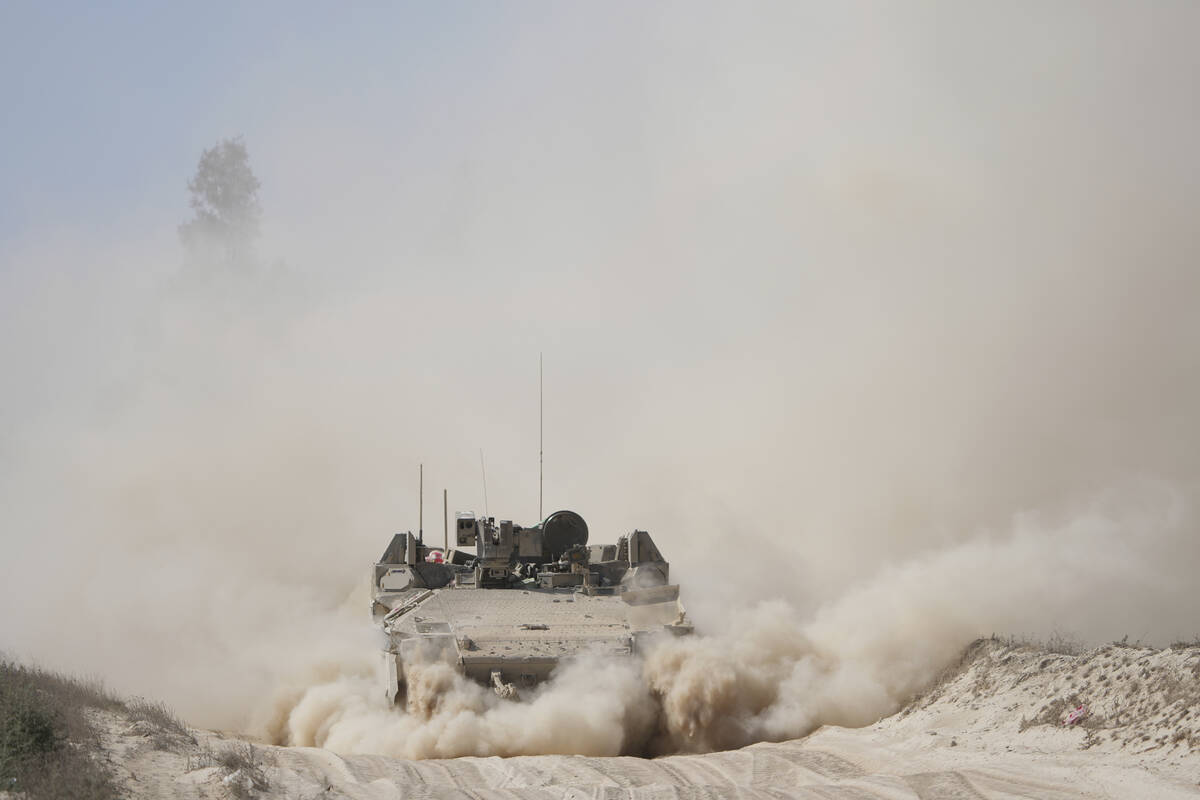 An Israeli army armored personnel carrier maneuvers near the Israel-Gaza border, southern Israe ...