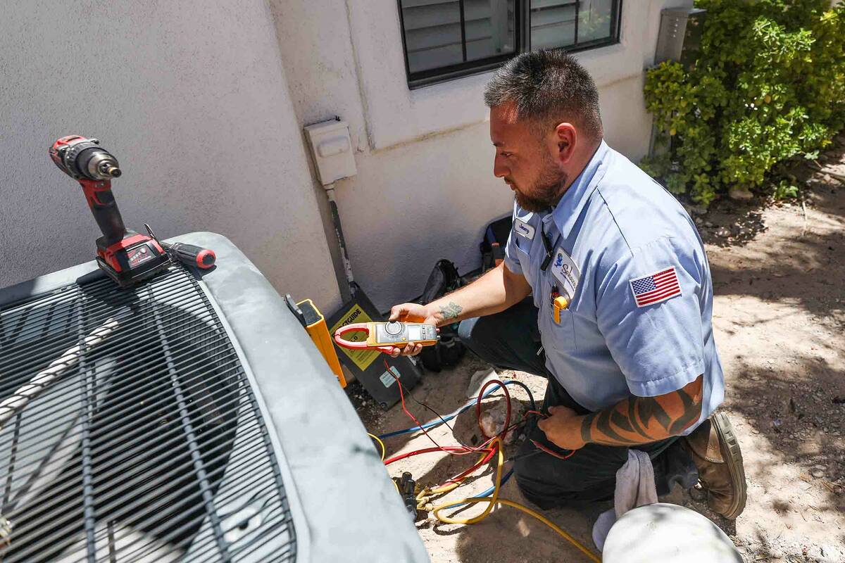 Service technician with Sahara Air Conditioning & Heating Jeremy Rojas repairs an air condition ...