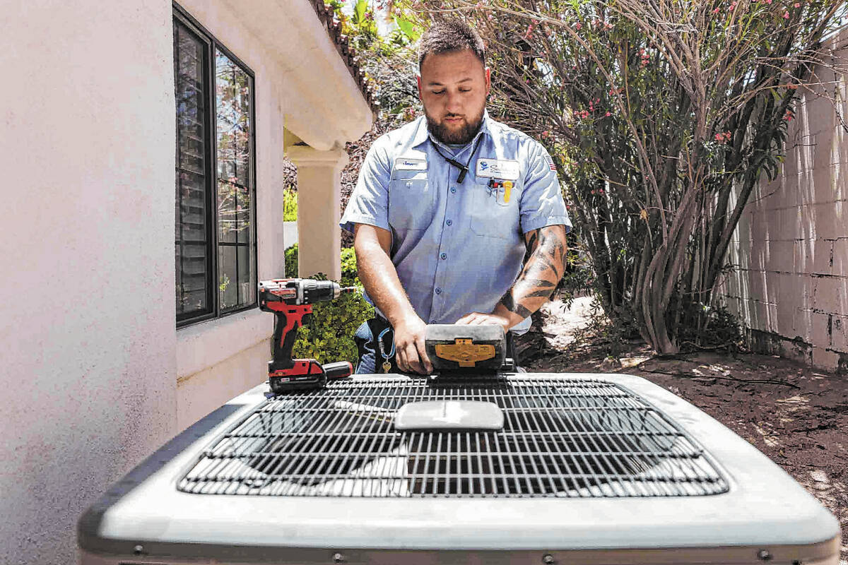 Service technician with Sahara Air Conditioning & Heating Jeremy Rojas repairs an air condition ...