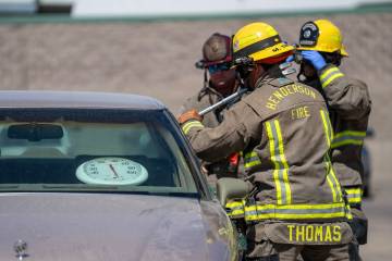 Firefighters Logan Stamm, Mike Plantin, and Matt Thomas break the car window during a simulatio ...